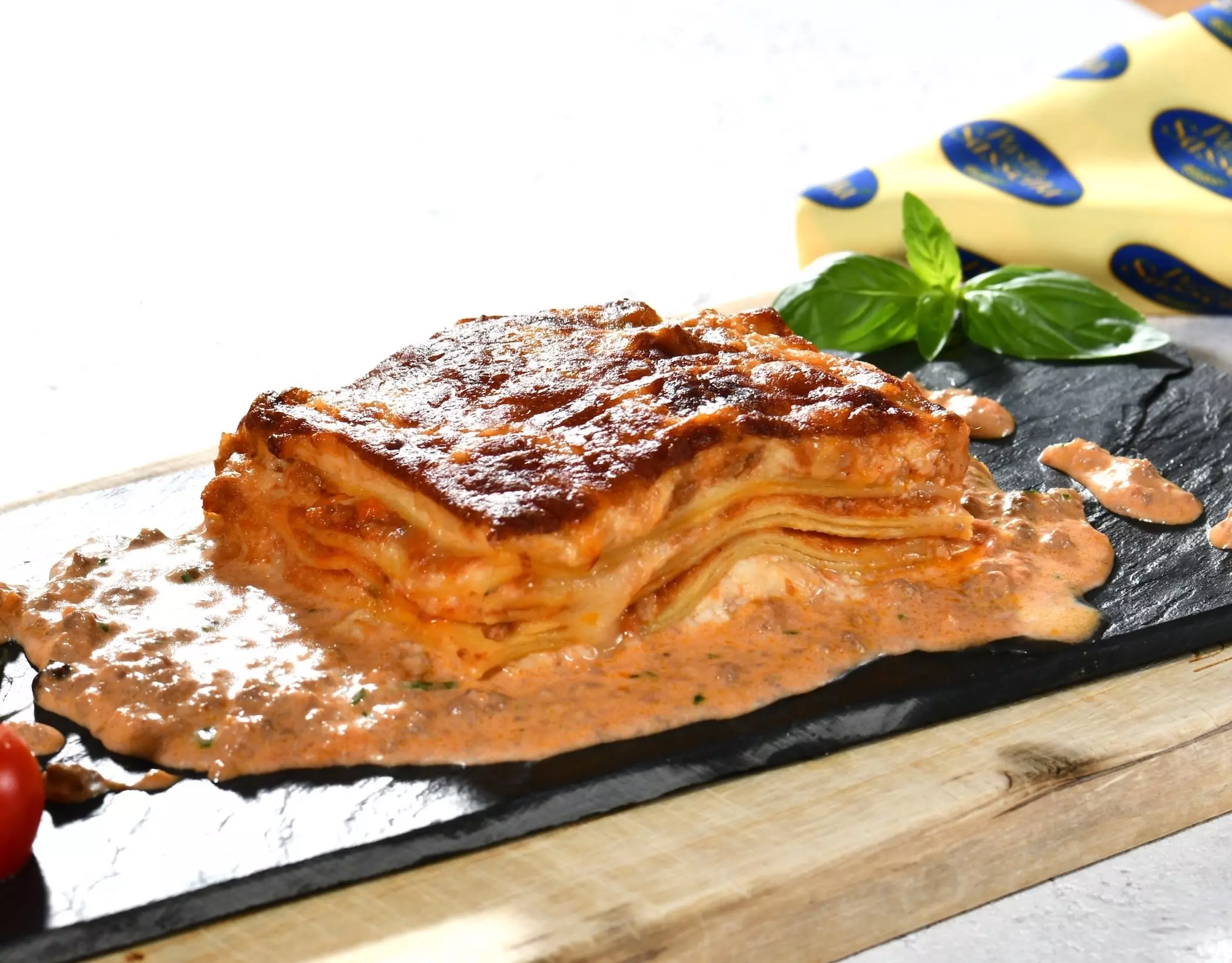 Lasagne-Stück mit cremiger Fleischsoße und Basilikum.